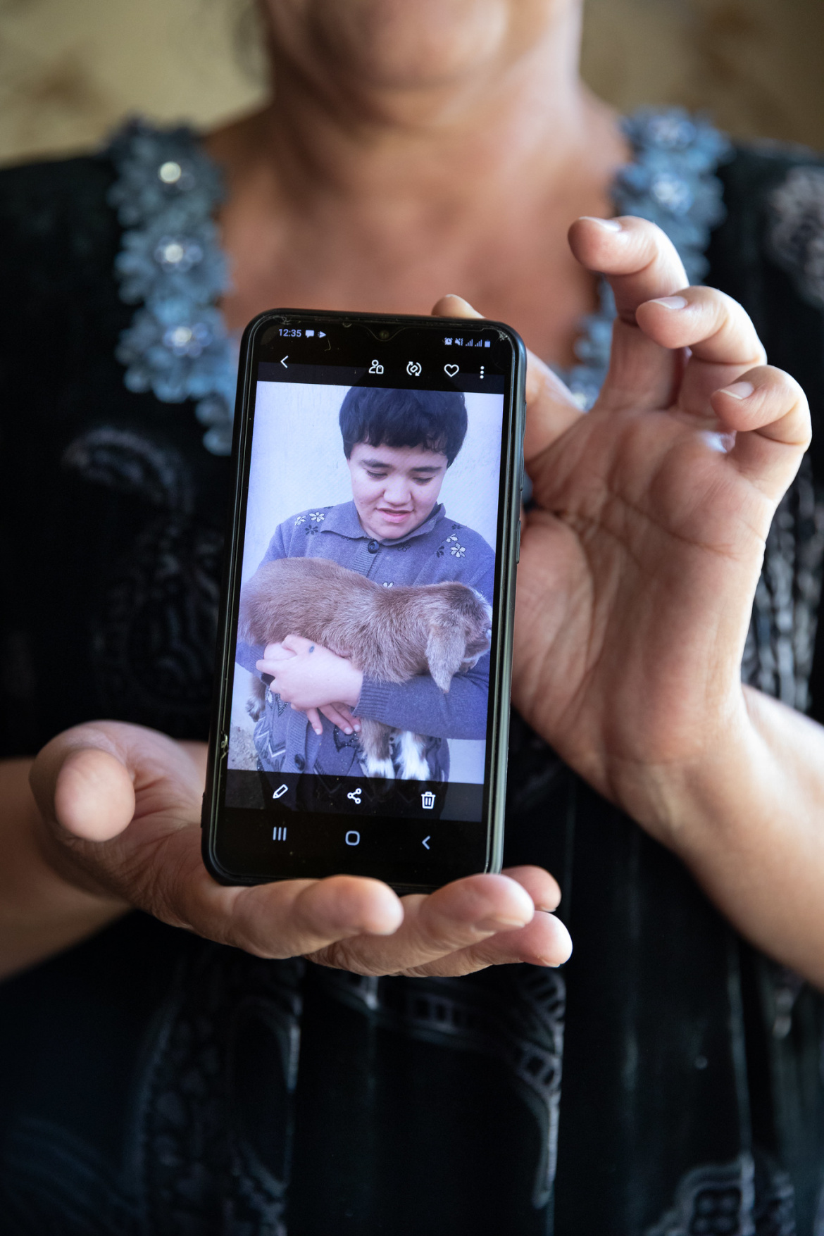 Hilola Mamadyorova montrant une photo de sa fille Zuhro. Âgée aujourd'hui de 21 ans, Zuhro est née autiste. Hilola a travaillé dur pour donner à sa fille une vie plus normale, y compris la possibilité d'aller à l'école.