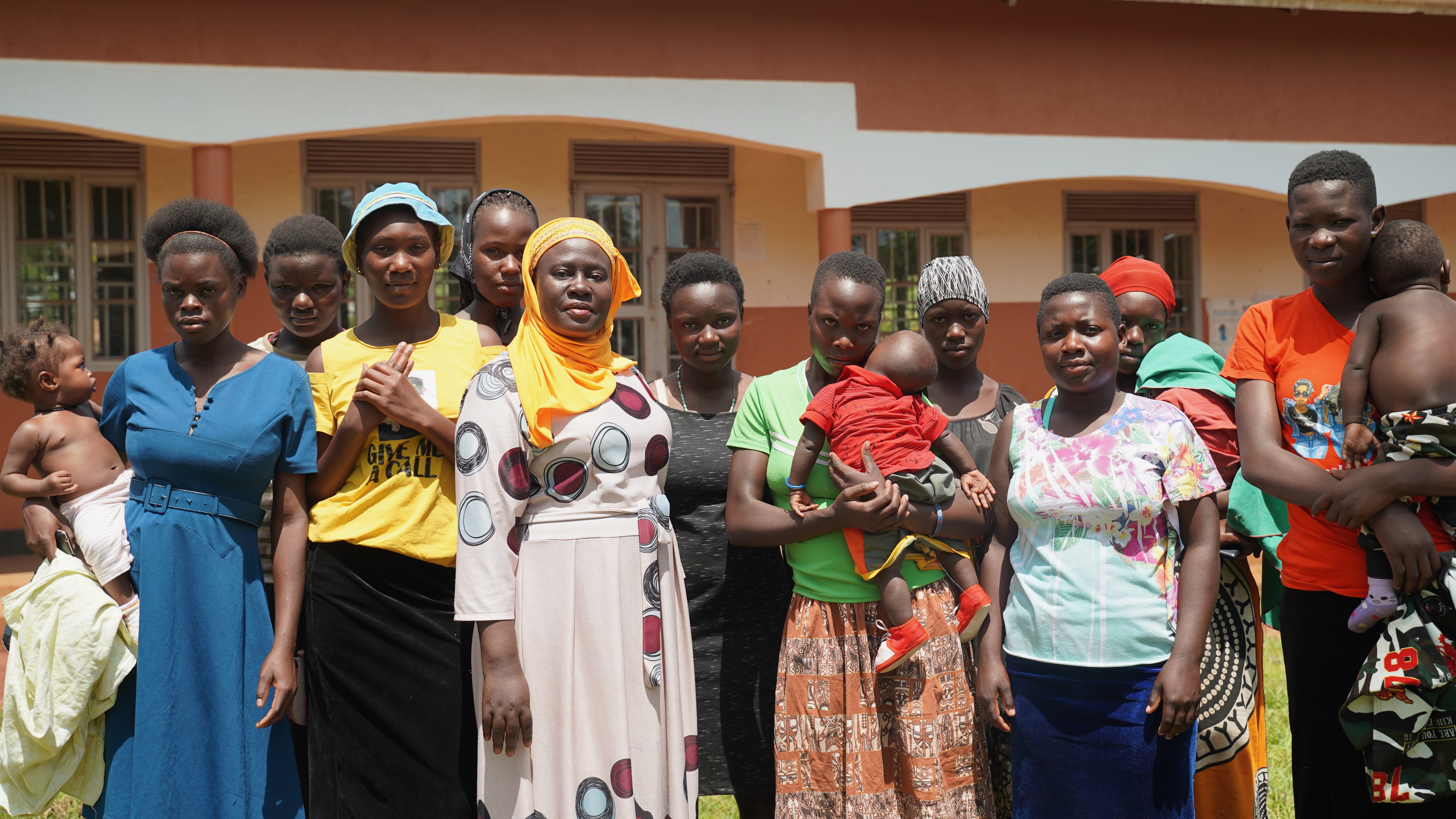 Nakayiza Amina (wearing a yellow scarf), headteacher of the Uganda Muslim Education Association primary school in Kisimba, standing with a group of girls who left school because they were pregnant but were able to return to school to sit their exams. Some of the girls are now mothers; others lost their babies. Photo: Caspar Haarløv