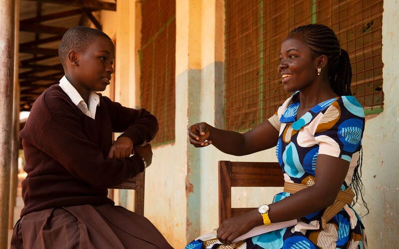CAMFED Learner Guide Sophia Leonard speaks with secondary student, Hanipha, at her school in Kilosa, Tanzania. Credit: CAMFED/Eliza Powell