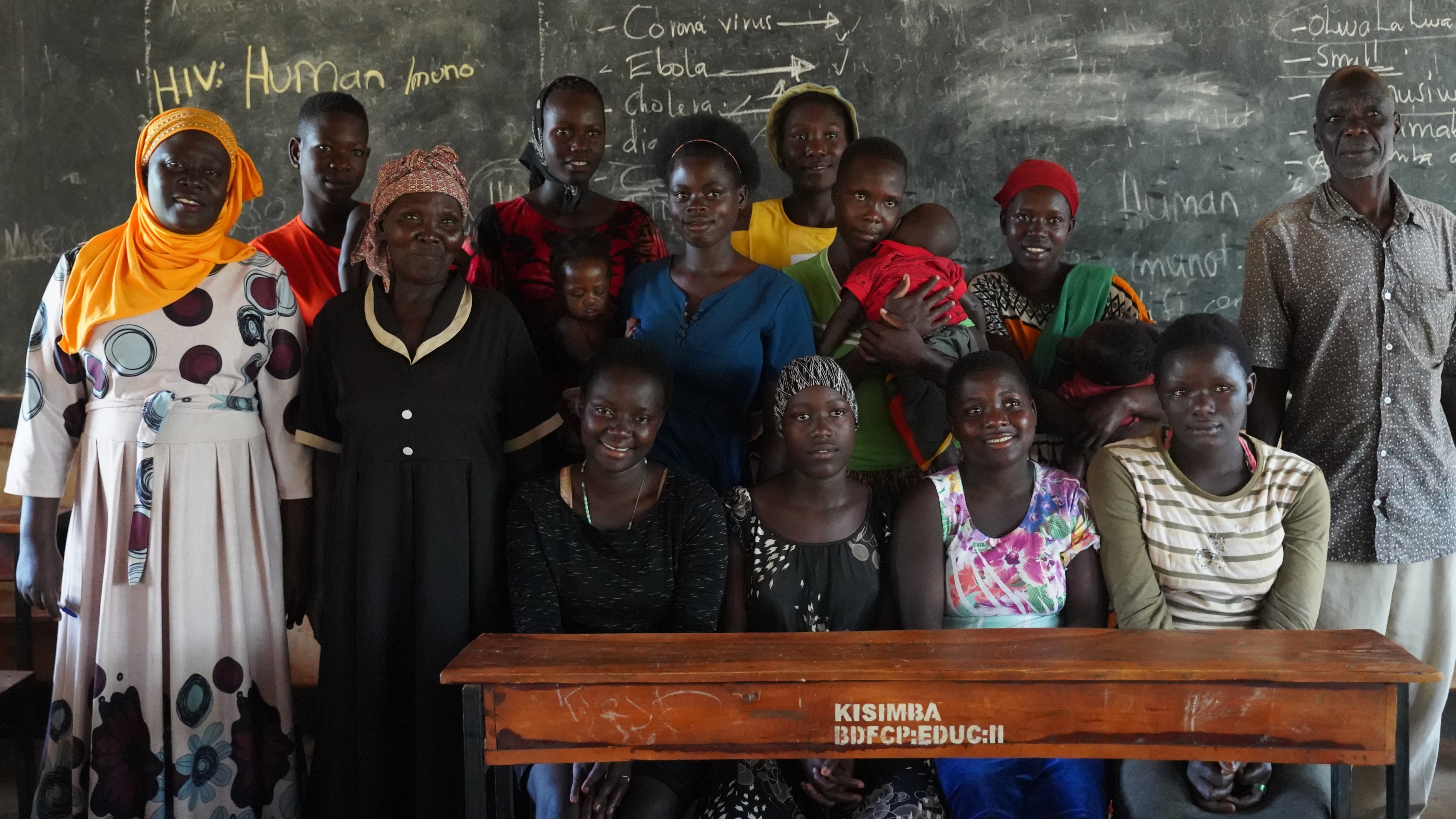 Nakayiza Amina, headteacher of the Uganda Muslim Education Association primary school in Kisimba, standing with a group of girls who left school because they were pregnant but were able to return to school to sit their exams. Some of the girls are now mothers; others lost their babies. Photo: Caspar Haarløv